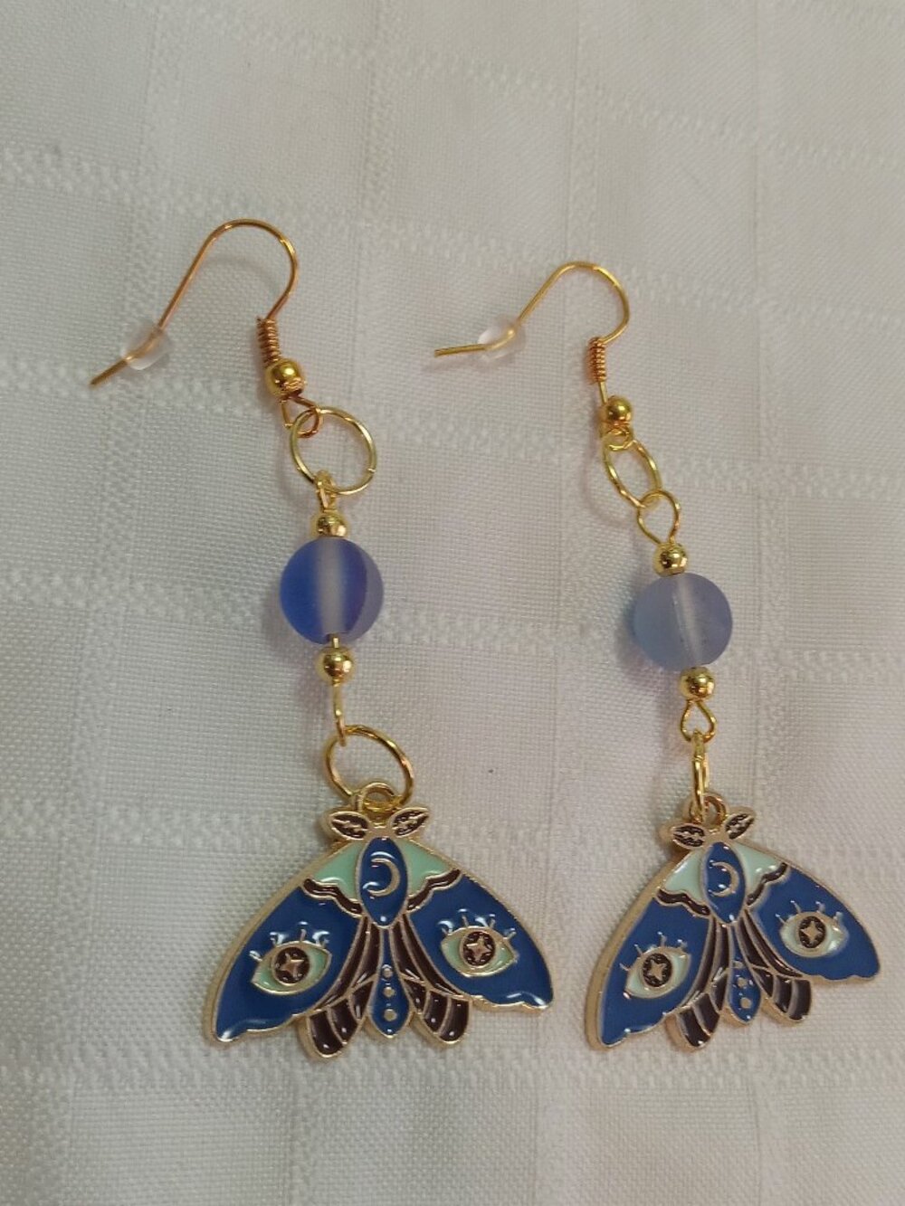 Handmade gold-colored earrings with multicolored enameled butterflies and beads